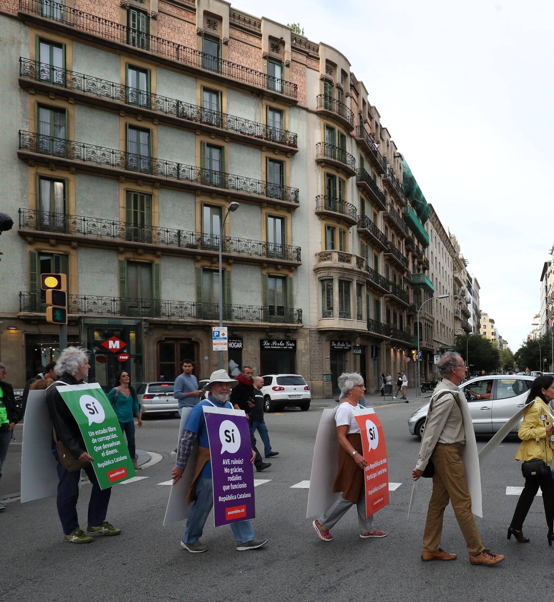 Catalan pro-independence supporters march while they distribute leaflets for the referendum on October 1 by Rambla de Catalunya in Barcelona