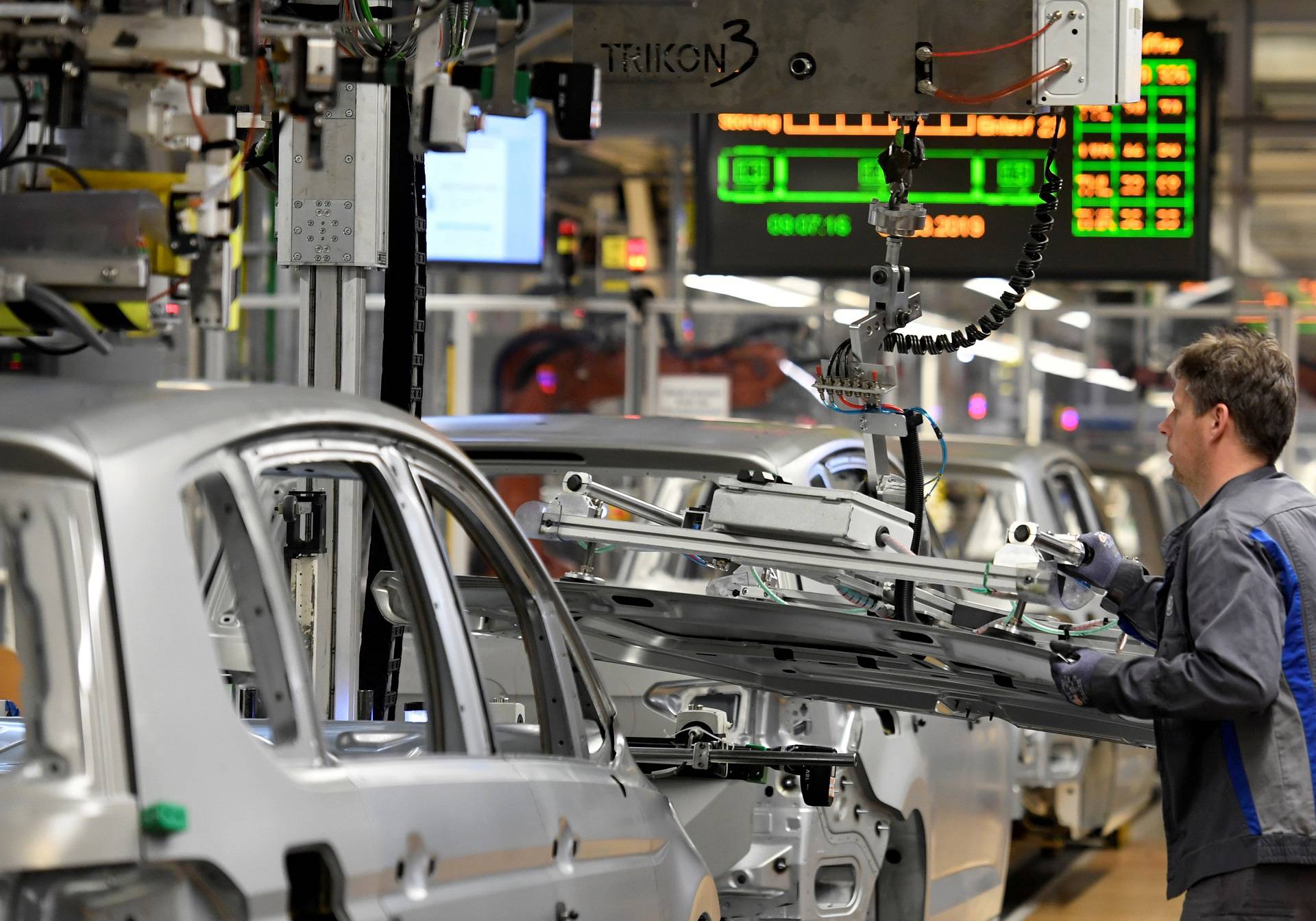 FILE PHOTO: An employee moves car components in a production line at the Volkswagen plant in Wolfsburg