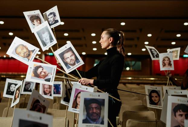A model poses while holding place sticks for guests during preparations for the BAFTA awards in London