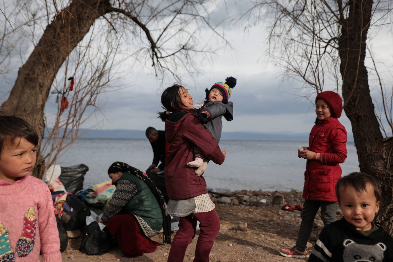 Migrants from Afghanistan who arrived the previous days, wait to be transferred to the port of Mytilene from the village of Skala Sikamias, on the island of Lesbos