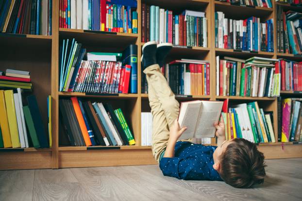 Boy,Laying,On,The,Floor,With,The,Feet,Up,,Reading
