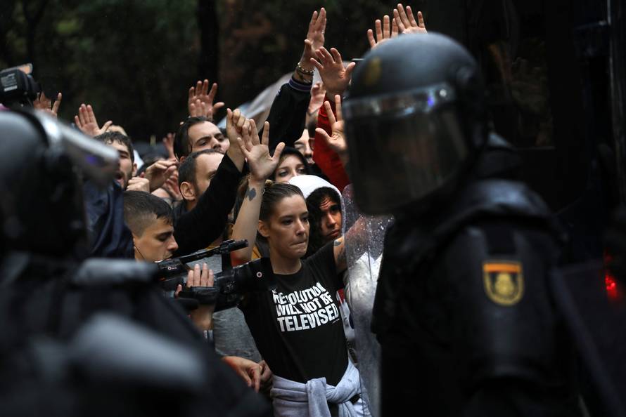 Demonstartors face riot police outside a polling station for the banned independence referendum in Barcelona