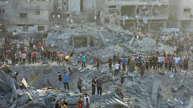 Palestinians search for casualties at the site of Israeli strikes on houses in Jabalia refugee camp