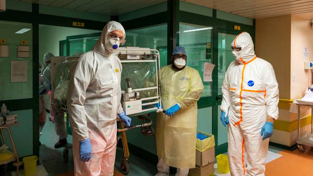 Medical workers in protective suits transfer a coronavirus patient from the intensive care unit of the Gemelli Hospital to the Columbus Covid Hospital, in Rome