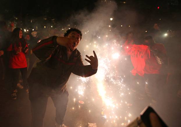 Fans light flares as they celebrate their win in Game 6 of the NBA basketball Finals between the Toronto Raptors and the Golden State Warriors on a large screen in a fan zone in Montreal