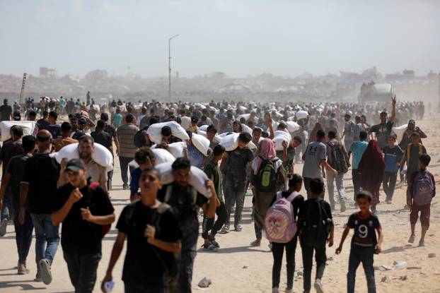 Palestinians gather to receive aid supplies amid a hunger crisis, in Beit Lahia