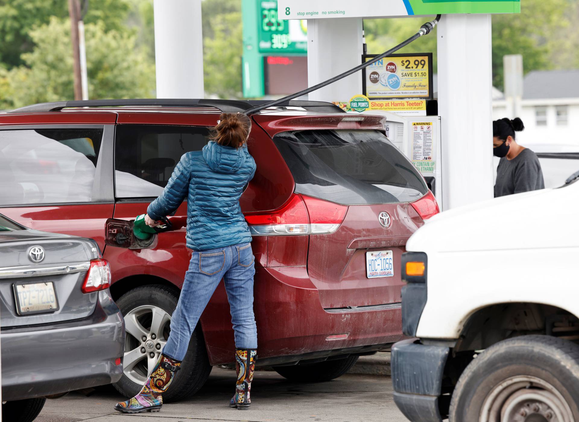 Motorist stretches fuel hose as gasoline station during surge in demand for fuel in Durham, North Carolina