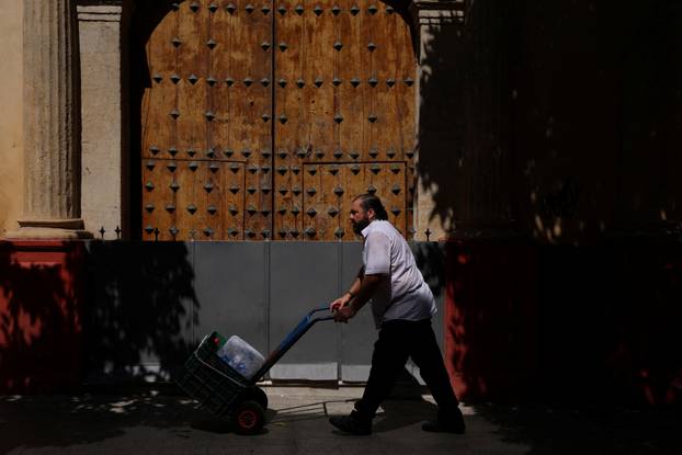 A man carries bottles of water during a heatwave in Seville