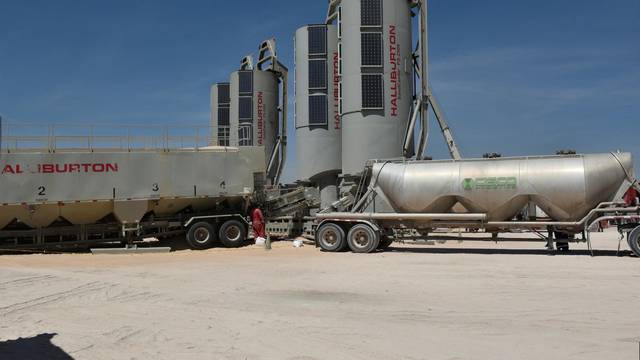 FILE PHOTO: Trucks filled with sand used in the fracking process are seen on a well site leased by Oasis Petroleum in the Permian Basin oil production area near Wink