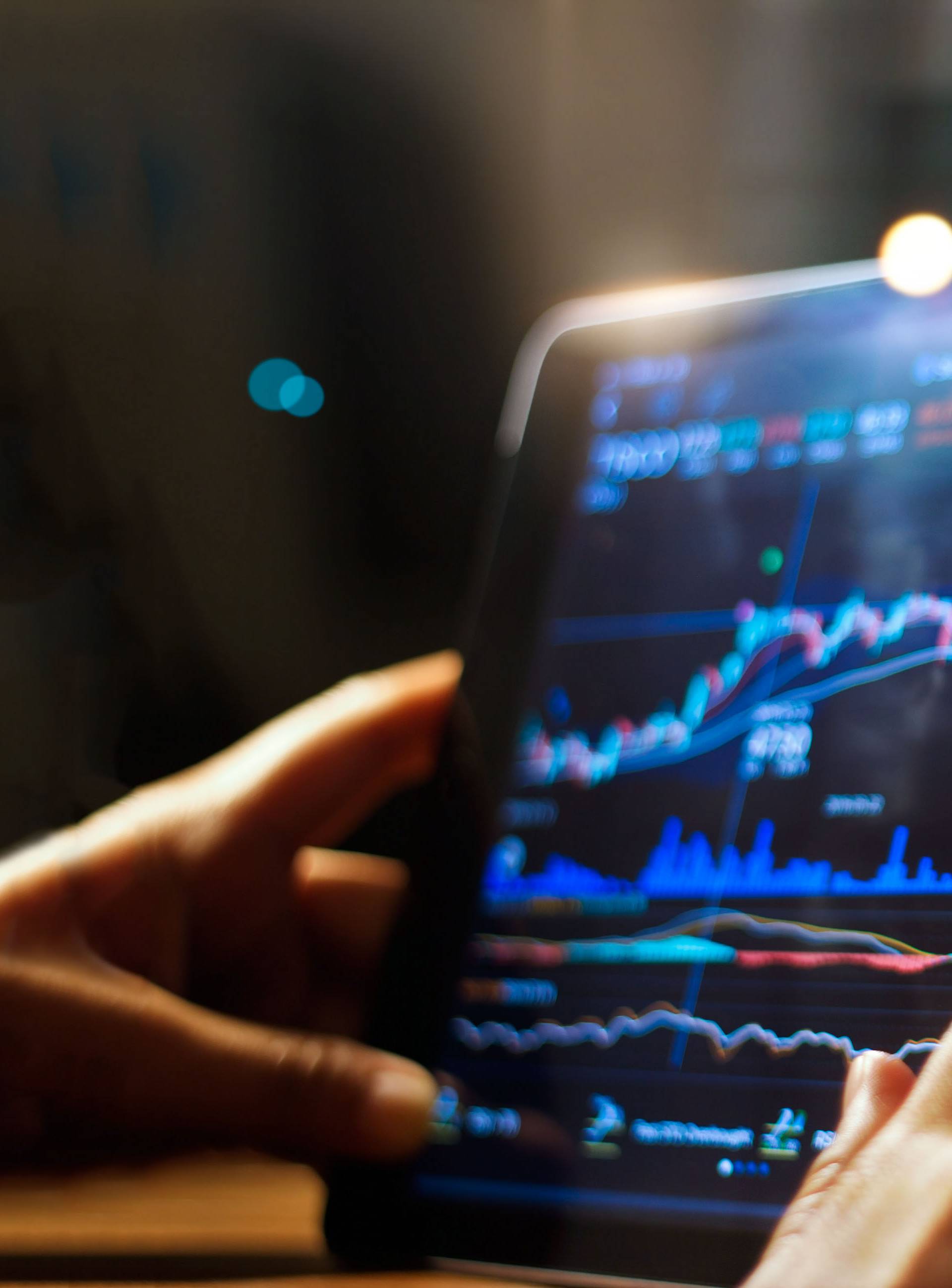 Businessman checking stock market data on tablet on night background