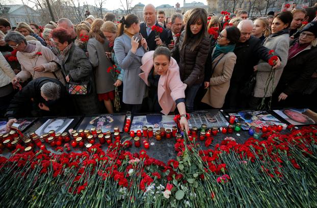 People attend a memorial to pay tribute to the victims of the St. Petersburg metro blast in central Moscow