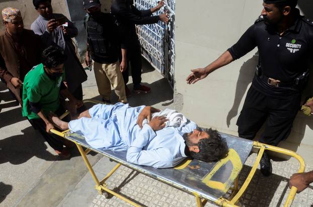 A medical staff moves an injured person, following an earthquake in Harnai, Balochistan, outside a hospital in Quetta
