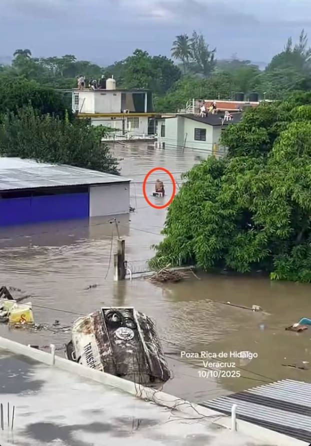 VIDEO: Elderly couple cling to each other on rooftop during devastating flood