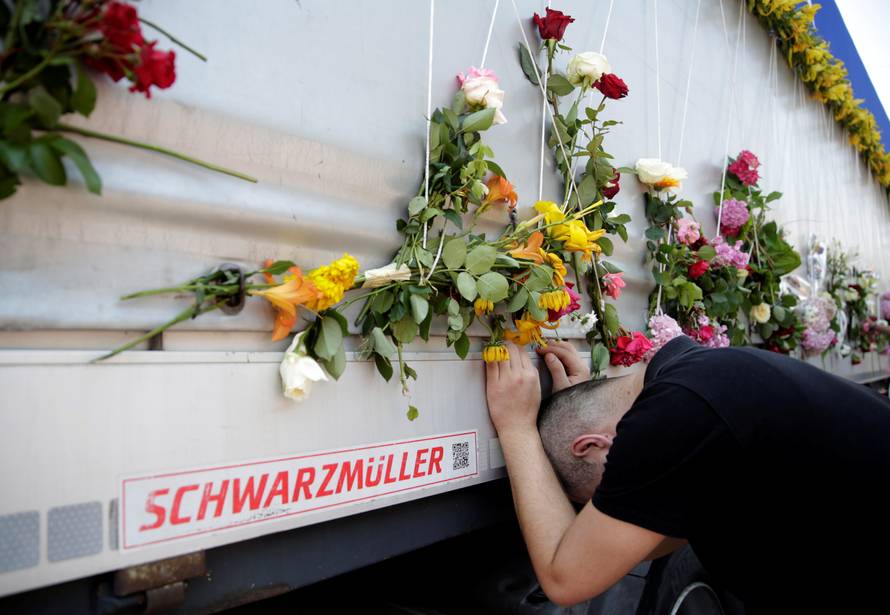 A man reacts near a truck carrying coffins of newly identified victims of the 1995 Srebrenica massacre, in front of the presidential building in Sarajevo