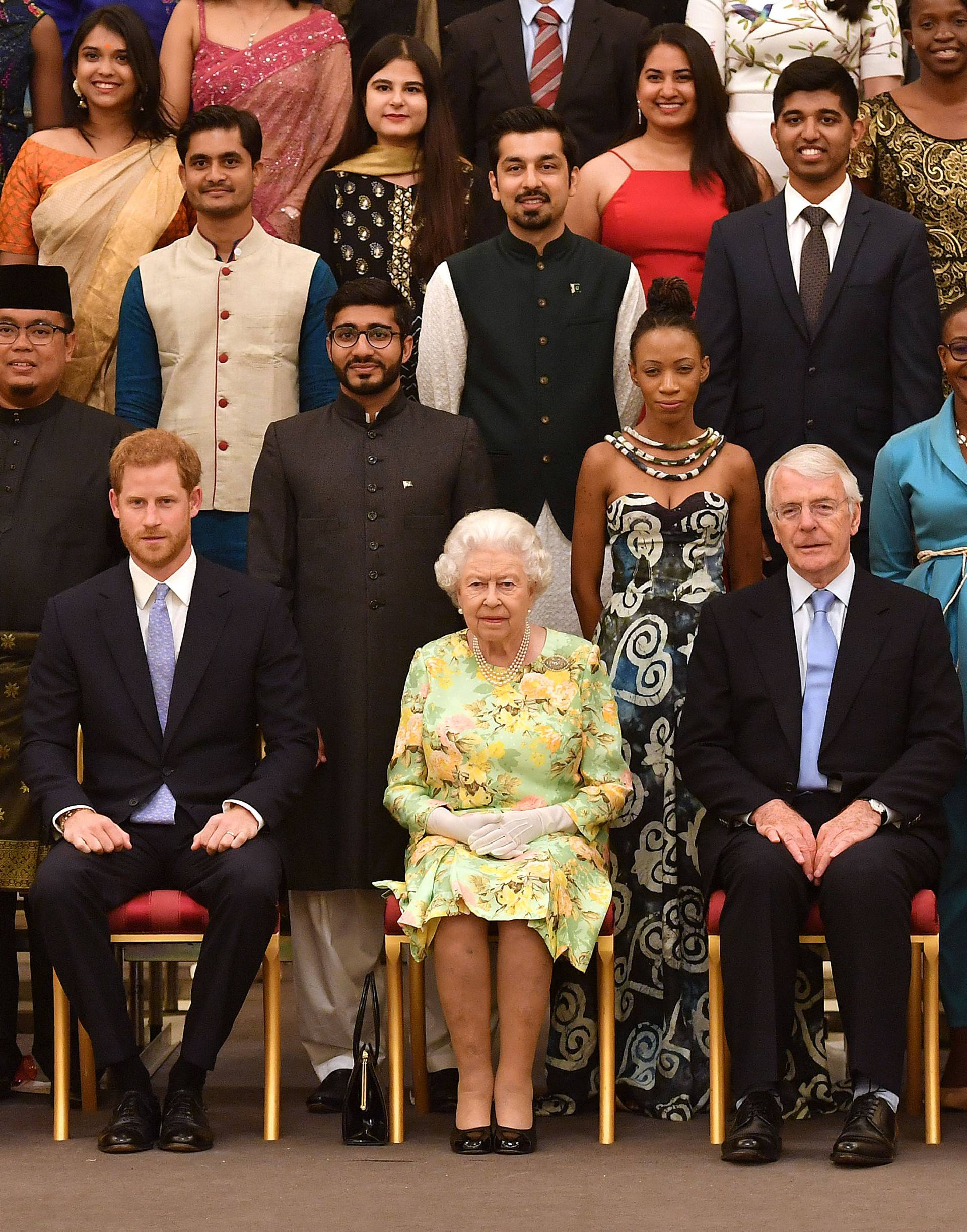 Britain's Queen Elizabeth, Prince Harry and Meghan, the Duchess of Sussex pose for a picture with some of Queen's Young Leaders at a Buckingham Palace reception following the final Queen's Young Leaders Awards Ceremony, in London