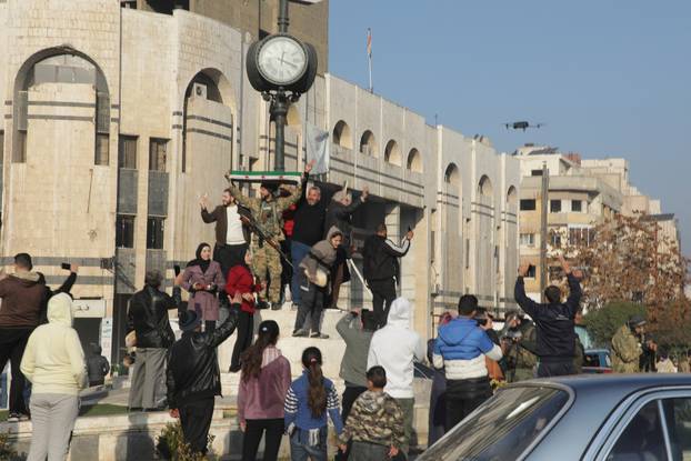 Syrian rebels and people celebrate in Homs
