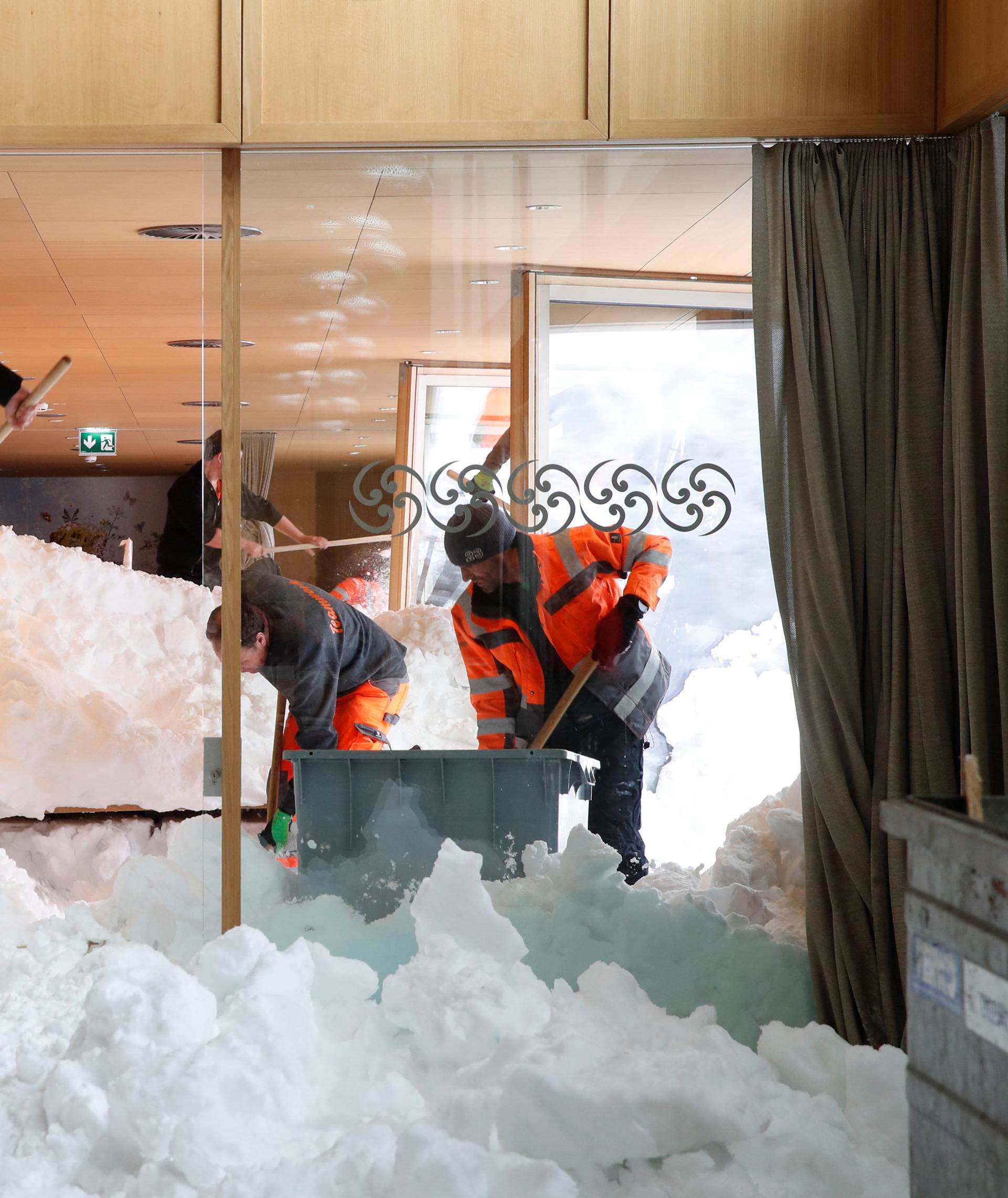 Workers shovel snow out of a restaurant after an avalanche at Santis-Schwaegalp mountain resort