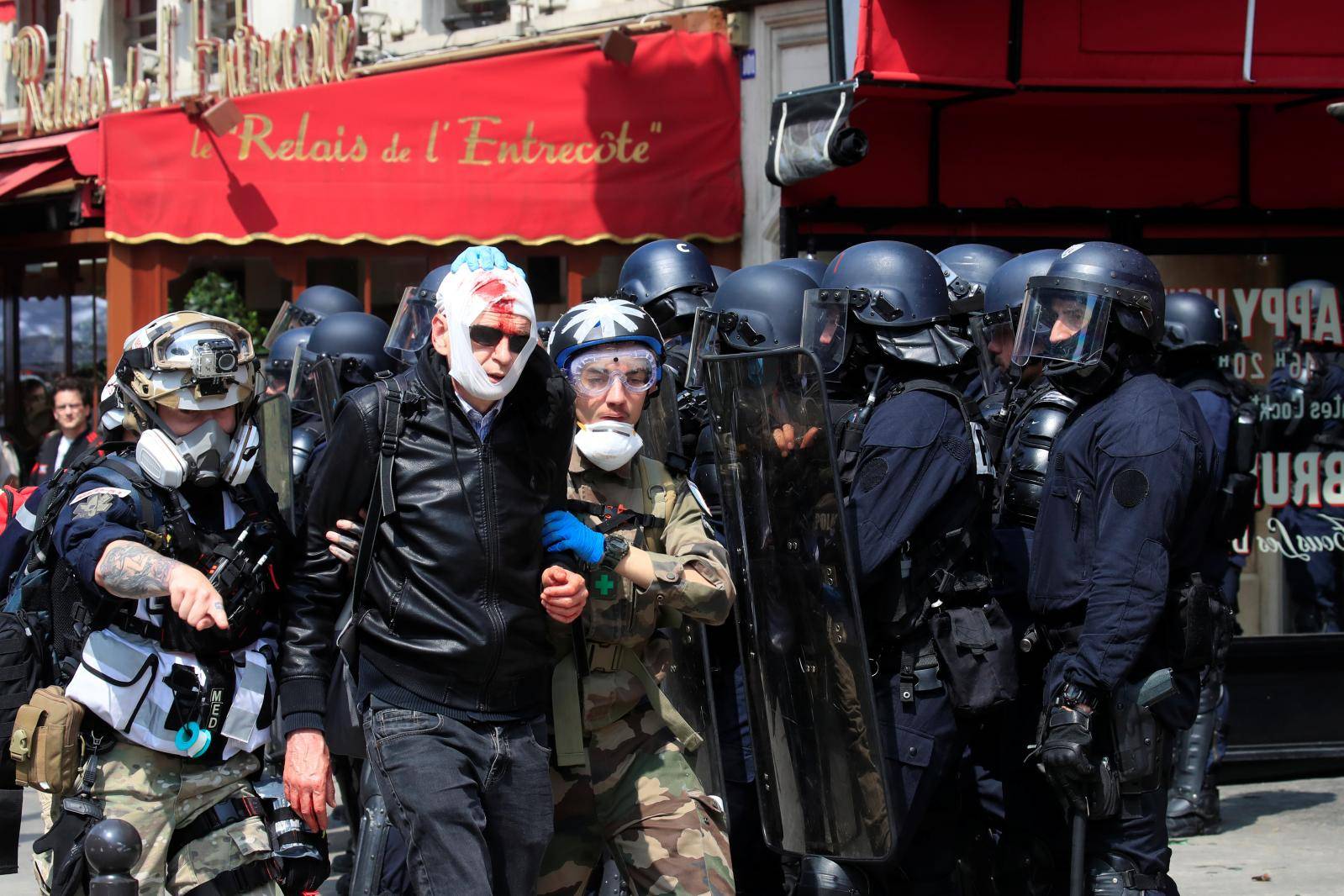 An injured protester is evacuated by street medics after clashes before the start of the traditional May Day labour union march in Paris