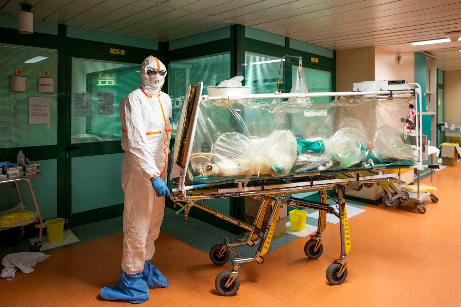 Medical workers in protective suits transfer a coronavirus patient from the intensive care unit of the Gemelli Hospital to the Columbus Covid Hospital, in Rome