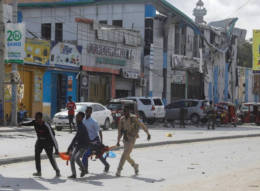 An injured civilian is evacuated from the scene of an explosion near the education ministry building along K5 street in Mogadishu