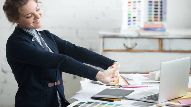 Young businesswoman stretching after work