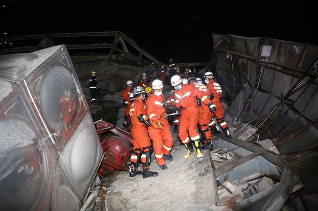 Rescue workers move casualty on the site where a hotel being used for the coronavirus quarantine collapsed, as the country is hit by the novel coronavirus,  in the southeast Chinese port city of Quanzhou, Fujian