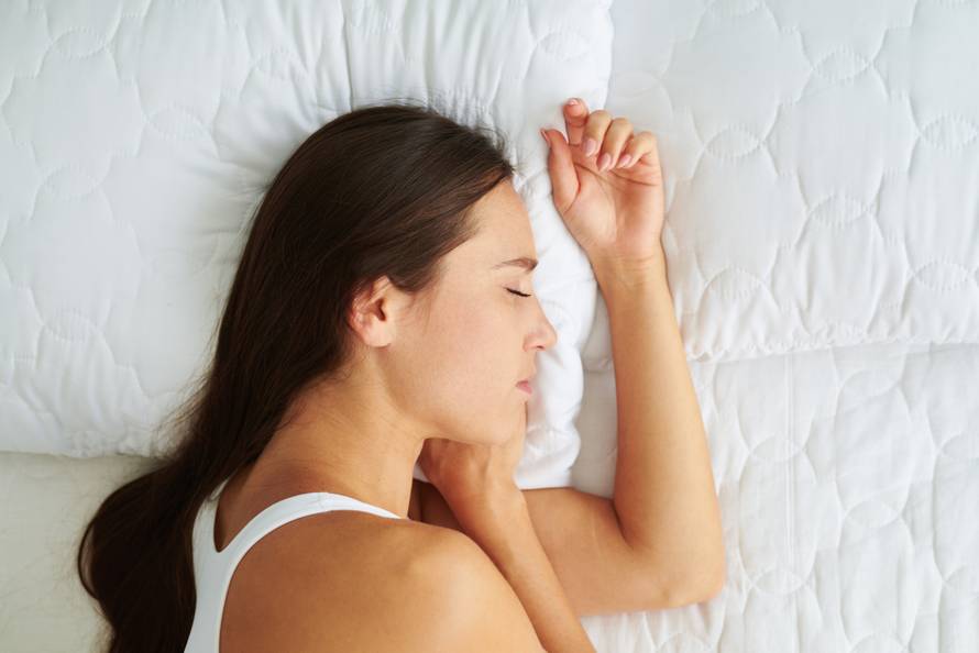 Young beautiful woman sleeping lying on the side in the bed