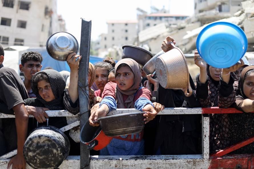 Palestinians receive food from charity kitchen, in Gaza City