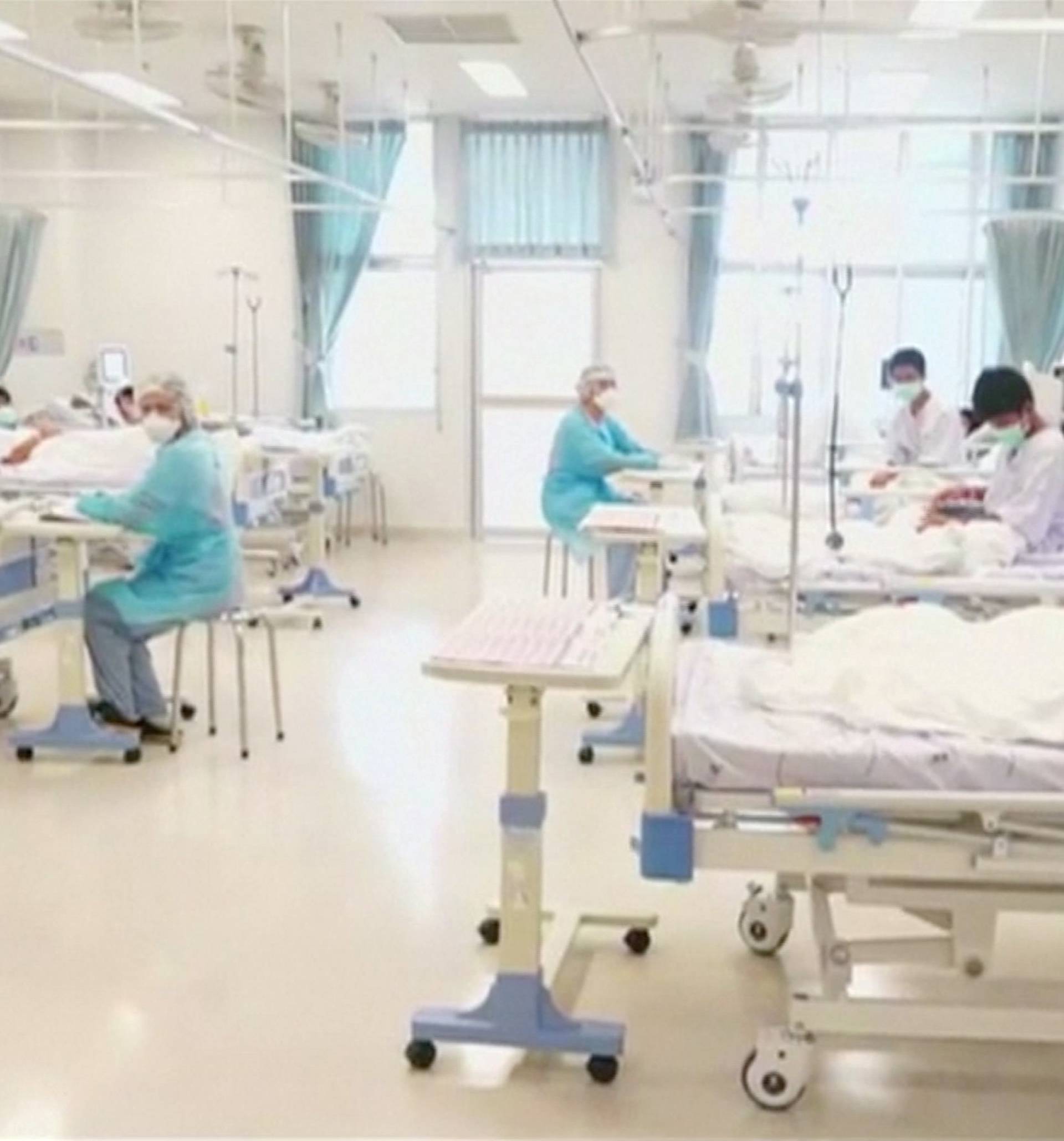 Boys rescued from the Thai cave wear masks and rest at a hospital in Chiang Rai