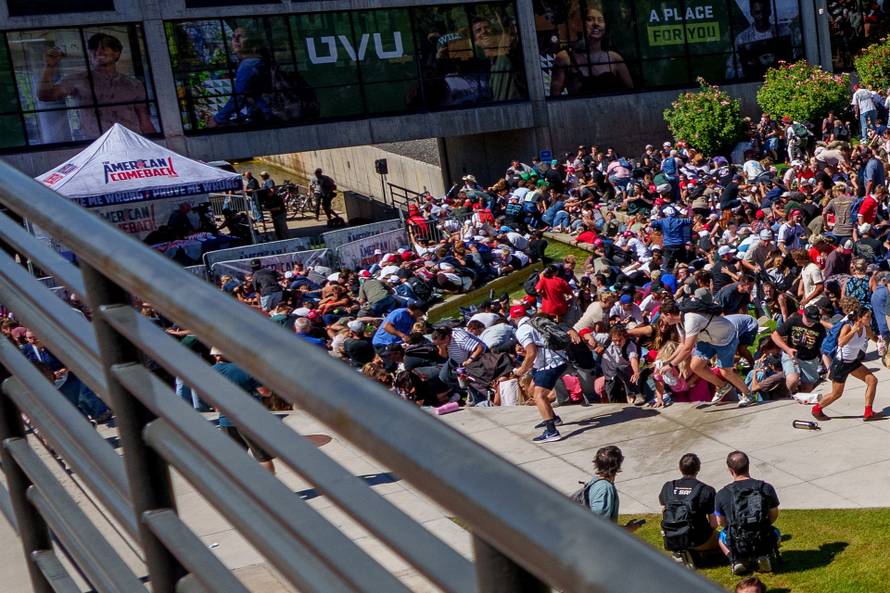 People run and crouch after U.S. right-wing activist and commentator Charlie Kirk was shot at a Utah Valley University speaking event in Orem