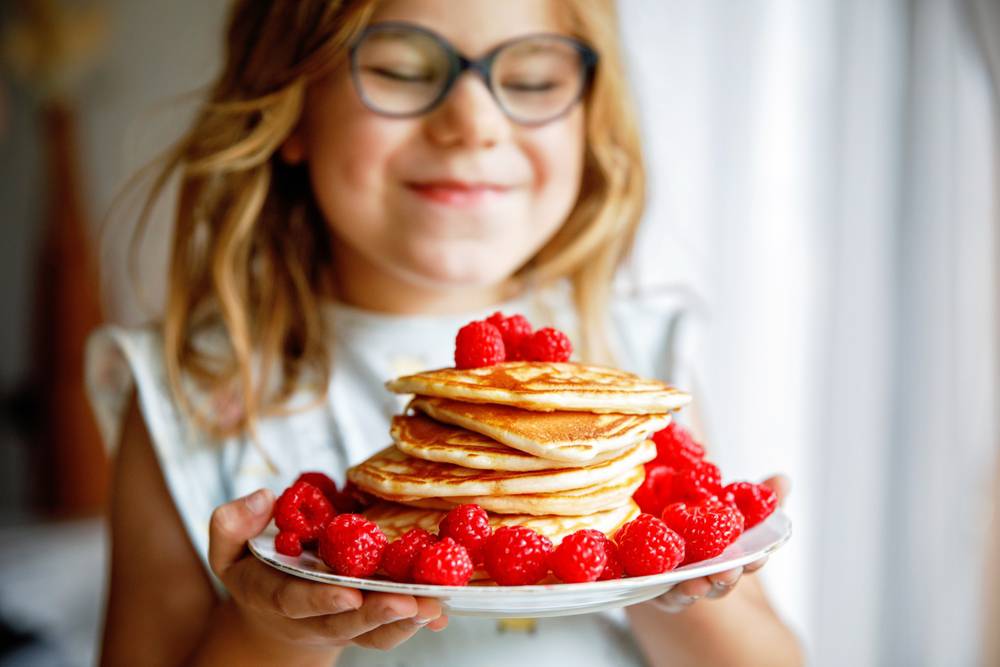 Little,Happy,Preschool,Girl,With,A,Large,Stack,Of,Pancakes