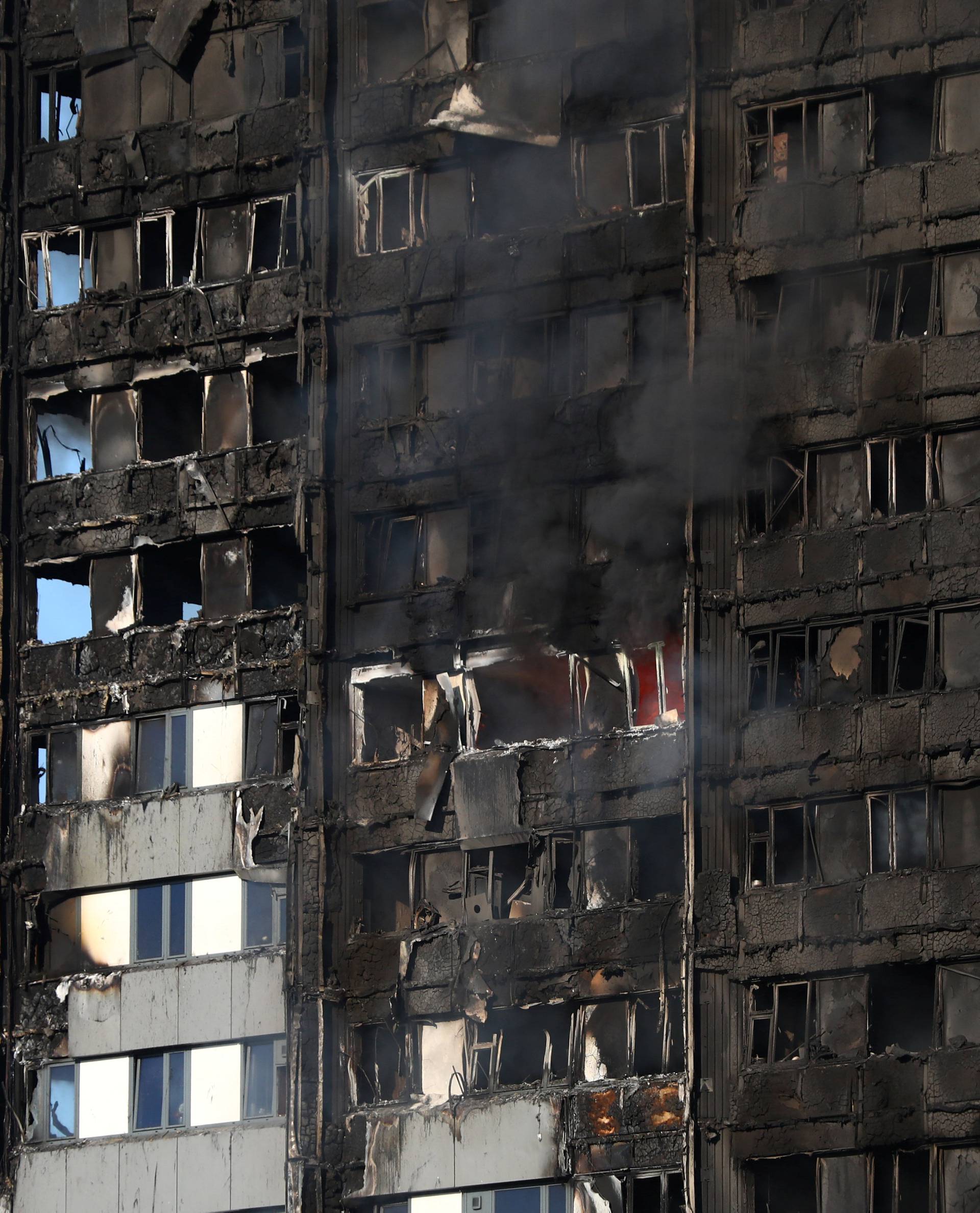 The burnt facade of a tower block is seen as firefighters tackle a serious fire at Latimer Road in West London