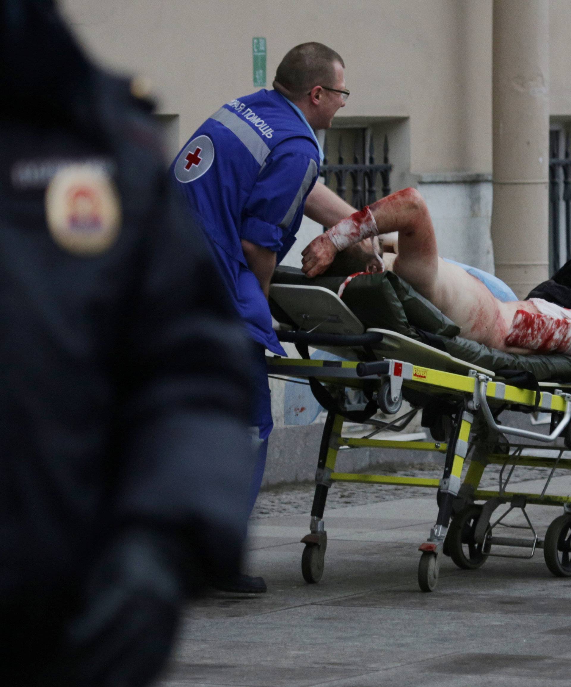 An injured person is helped by emergency services outside Sennaya Ploshchad metro station following explosions in St. Petersburg