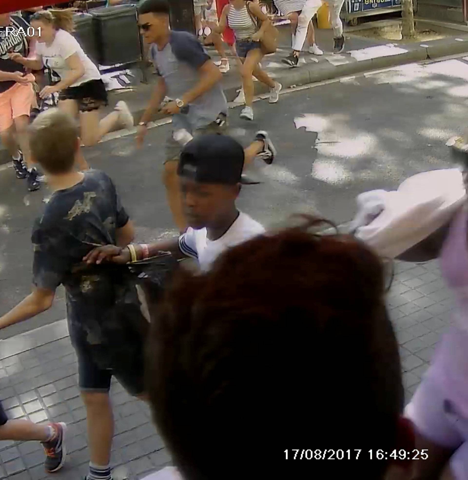 A still image from a CCTV footage shows people as they flee to safety during a van attack further down the street on La Rambla, in Barcelona