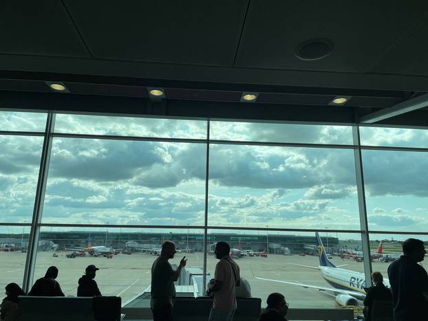 Passengers awaiting news on cancelled or delayed flights at London's Stansted Airport gesture as they discuss the situation on Monday, in London