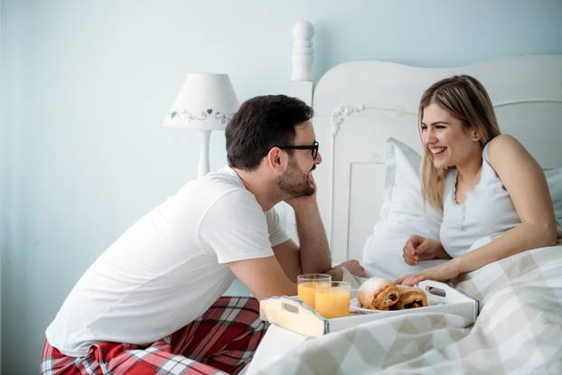 Portrait of young loving couple in bedroom