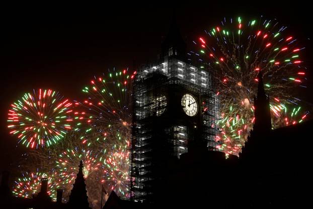 Fireworks explode behind the Elizabeth Tower, commonly known as Big Ben, during New Year