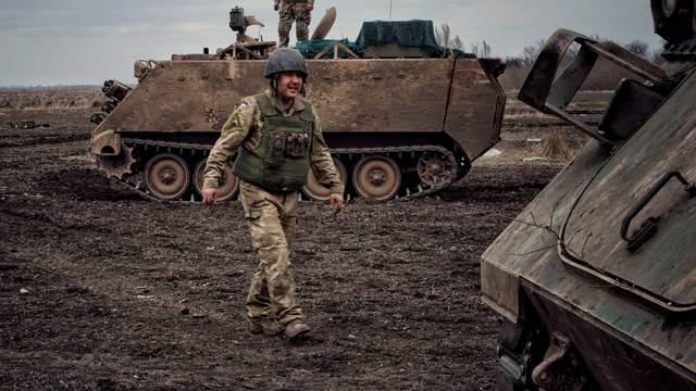 A Ukrainian serviceman walks near at M113 Armoured Personnel Carrier in Donbas region