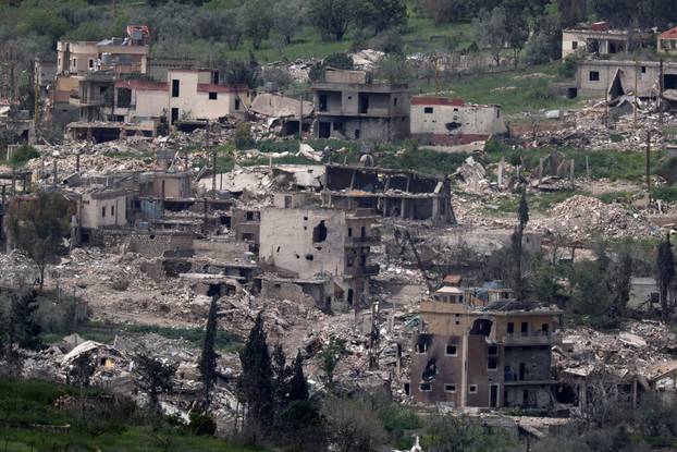 Damaged buildings on the Lebanese side of the Israel-Lebanon border as a armed vehicle stands, after a 10-day ceasefire between Lebanon and Israel went into effect, as seen from Israel