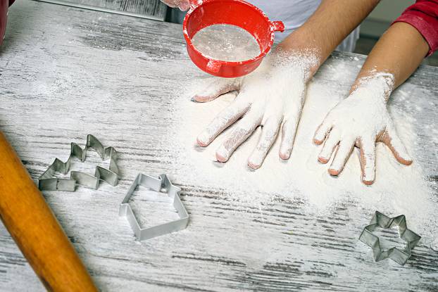 Happy family making dough in white kitchen