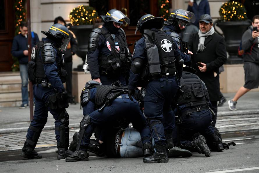 French CRS riot police apprehend a protester during a national day of protest by the "yellow vests" movement in Paris