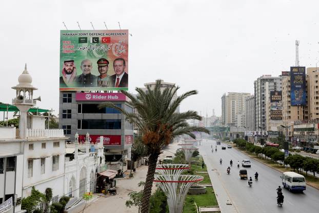 Billboard displays leaders following the signing of the Makkah Joint Defence Agreement, in Karachi