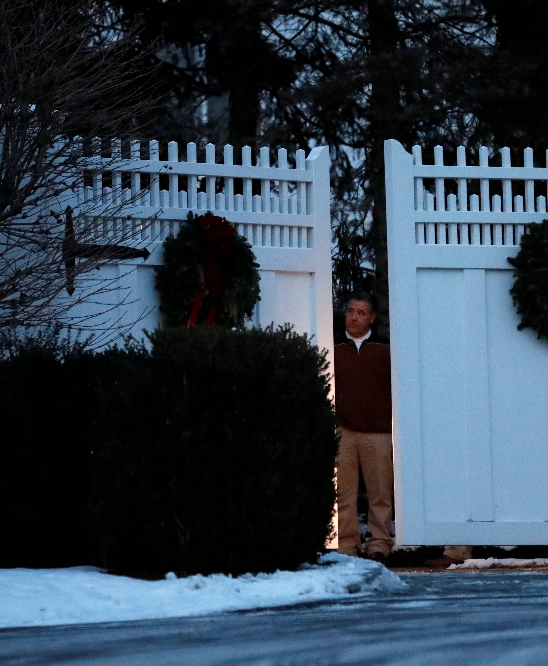 A man is seen at the gate to the home of former U.S. President Bill Clinton and former Democratic presidential candidate Hillary Clinton after firefighters were called to put out a fire at the property in Chappaqua
