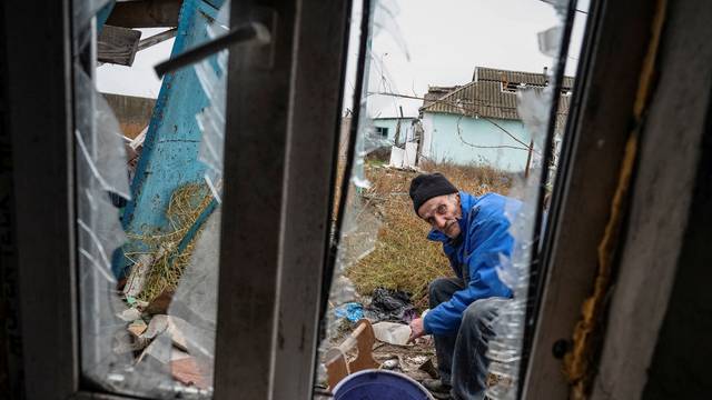 Mykhailo, 65, a local resident, repairs his destroyed house in the village of Pokrovskii Posad