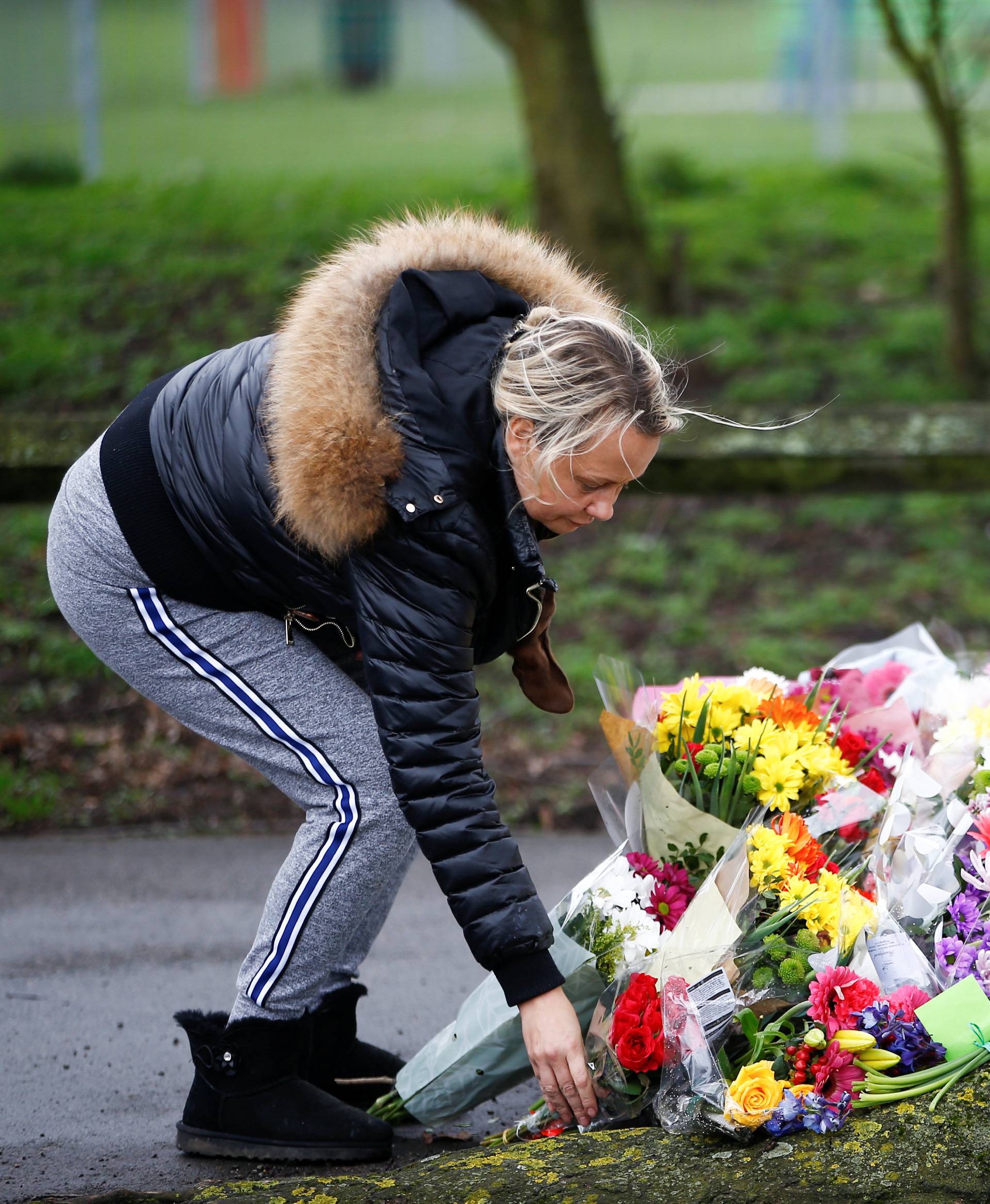 A woman lays flowers near to where 17-year-old Jodie Chesney was killed, at the Saint Neots Play Park in Harold Hill, east London
