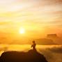 Woman meditating in sitting yoga position on the top of a mountains