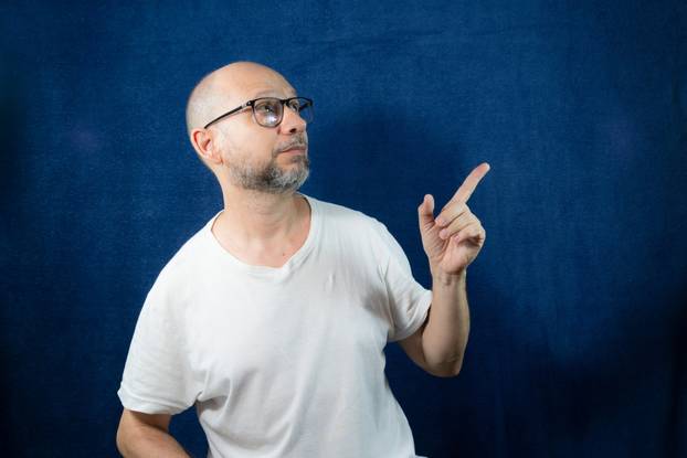 Portrait of a bearded man wearing eyeglasses against a blue back