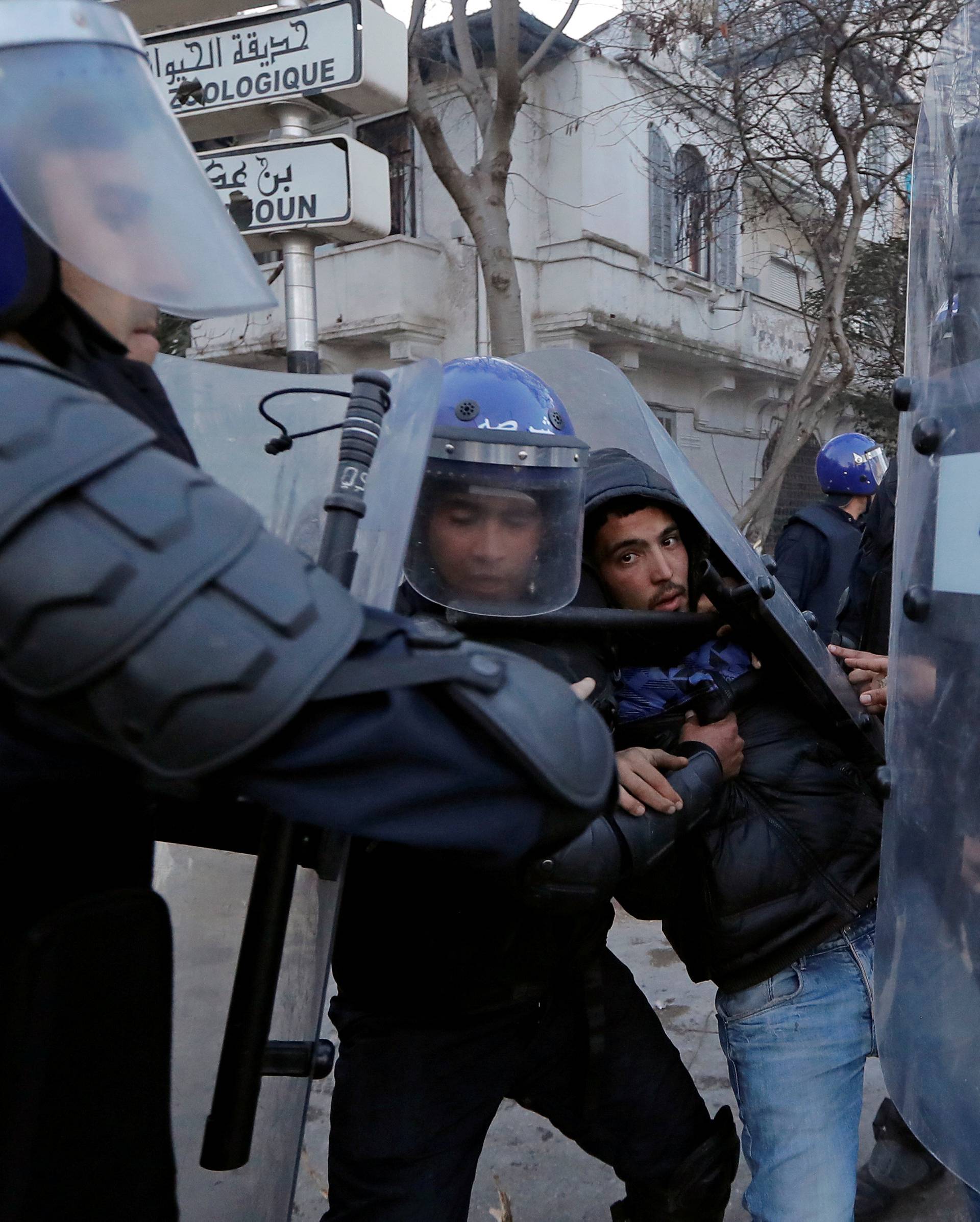 Anti-riot police officers detain a man who was protesting against President Abdelaziz Bouteflika's plan to extend his 20-year rule by seeking a fifth term in April elections in Algiers