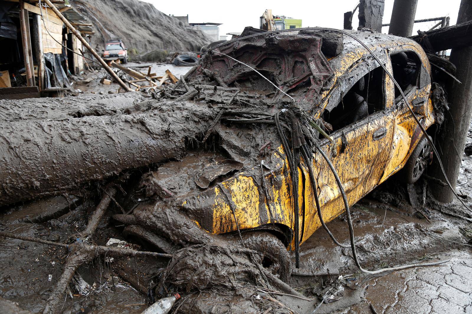 Firefighter rescue crews searching homes and streets covered by mud in Quito