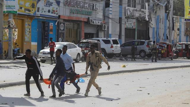 An injured civilian is evacuated from the scene of an explosion near the education ministry building along K5 street in Mogadishu